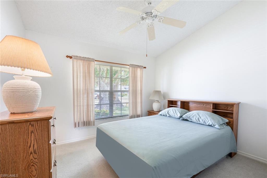 814 Charlemagne Boulevard Naples, FL 34112 - Photo 20 of 33 a bedroom with a bed and a chandelier