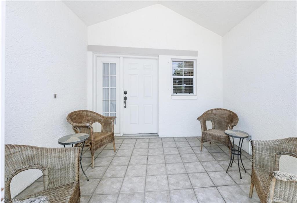 814 Charlemagne Boulevard Naples, FL 34112 - Photo 2 of 33 a living room with chairs and a table