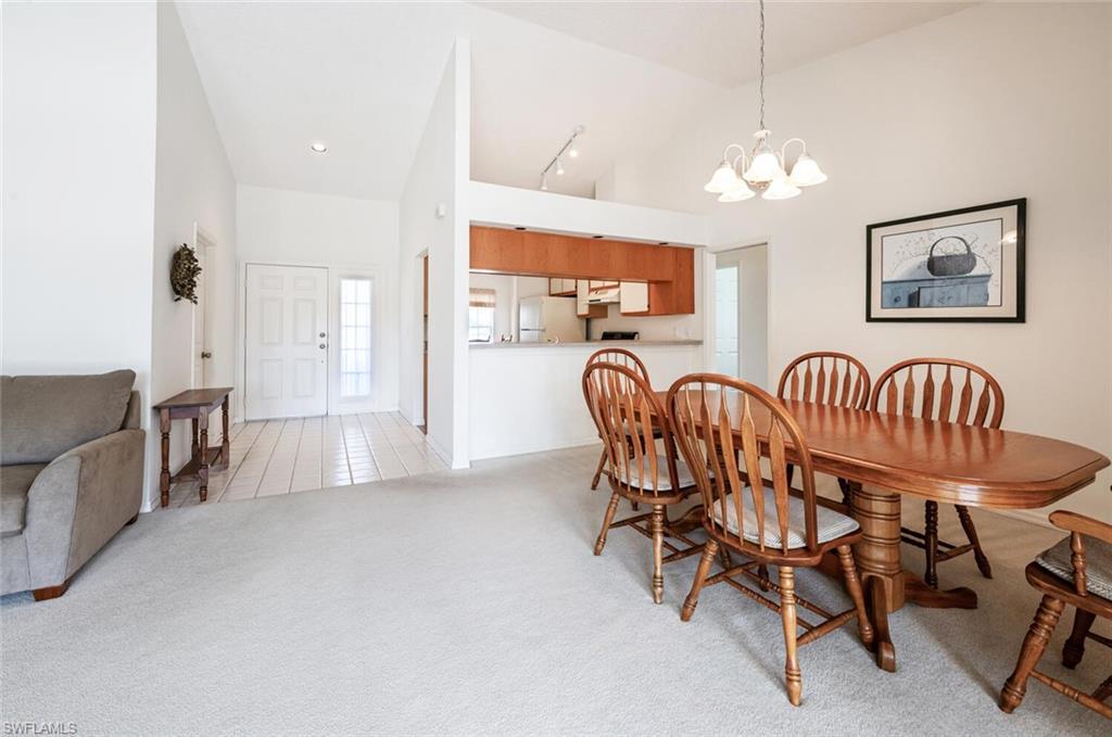 814 Charlemagne Boulevard Naples, FL 34112 - Photo 4 of 33 a dining room with furniture and chandelier