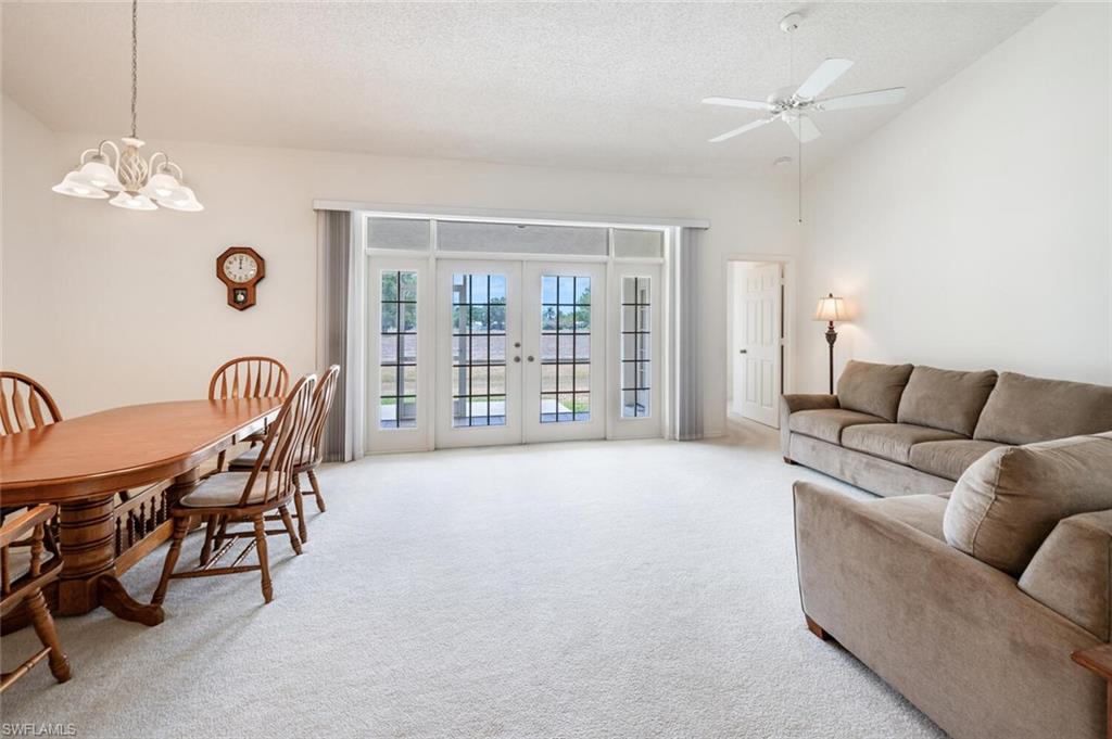 814 Charlemagne Boulevard Naples, FL 34112 - Photo 5 of 33 a living room with furniture a dining table and a chandelier