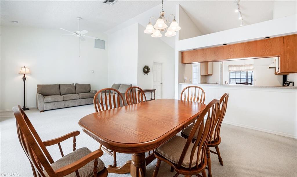 814 Charlemagne Boulevard Naples, FL 34112 - Photo 8 of 33 a dining room with furniture a chandelier and window