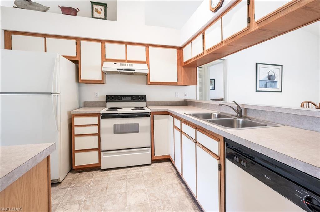 814 Charlemagne Boulevard Naples, FL 34112 - Photo 9 of 33 a kitchen with a sink stove and refrigerator