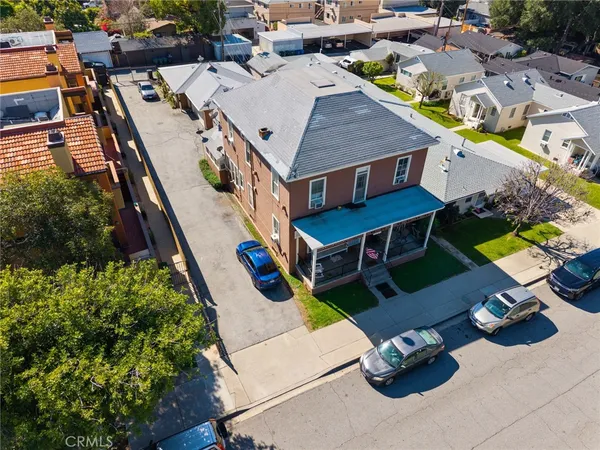 an aerial view of a house with swimming pool and lawn chairs