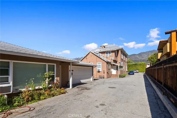 a view of a house with a small yard and potted plants