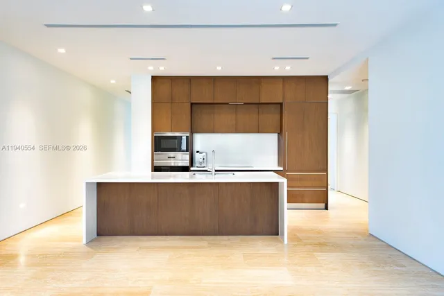 a view of kitchen with stainless steel appliances wooden cabinets and a sink