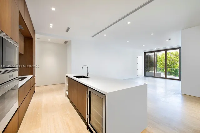 a kitchen with granite countertop a sink a counter top space stainless steel appliances and cabinets