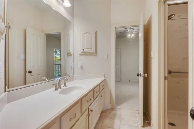 an empty room with windows and fan chandelier