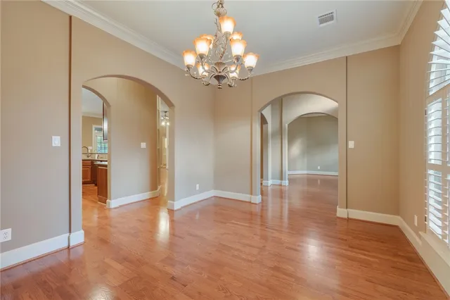 a kitchen with stainless steel appliances granite countertop wooden floors wooden cabinets a sink and a window