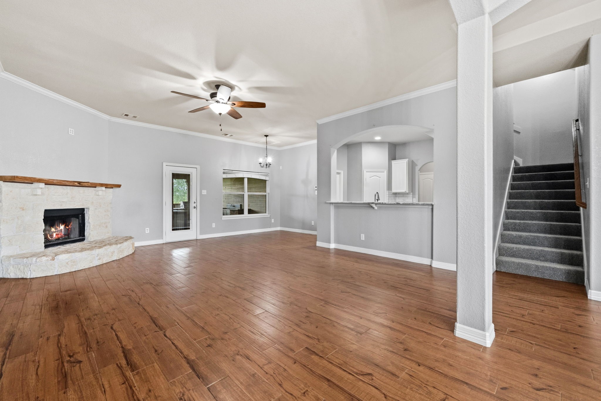 1405 Big Hill Road Winnie, TX 77665 - Photo 20 of 43 a view of an empty room with wooden floor kitchen view and a fireplace