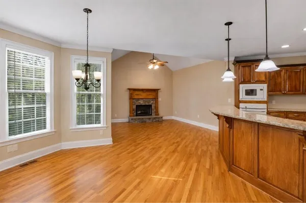 a view of a room with wooden floor and a ceiling fan