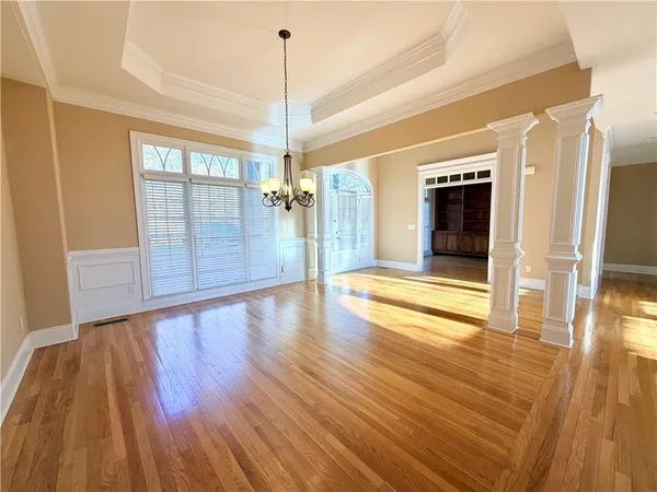 a view of an empty room with wooden floor