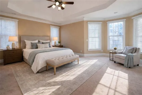 a bedroom with a bed couches and windows