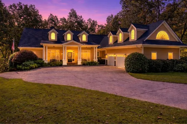 a front view of a house with yard and green space