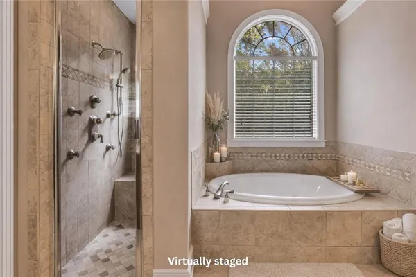 a bathroom with a tub a window and a shower