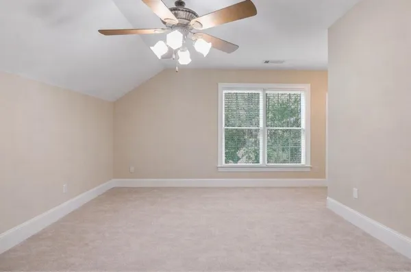 an empty room with a window and a fan