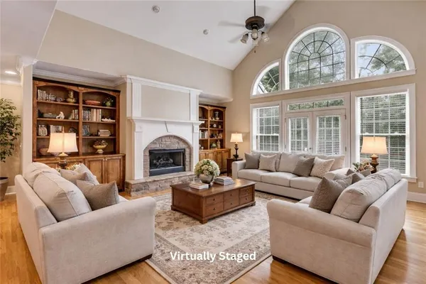 a living room with furniture a fireplace and a large window