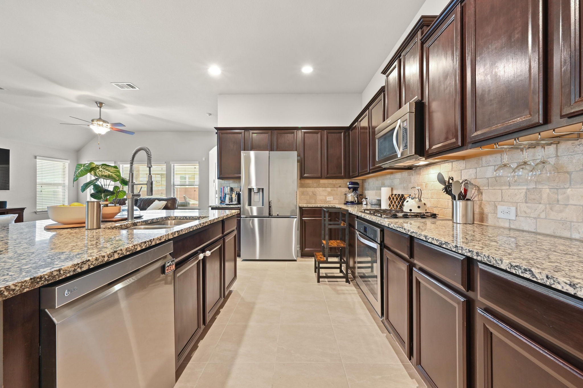 546 Hot Spring Valley Buda, TX 78610 - Photo 11 of 27 Kitchen with stainless steel appliances, light stone counters, dark wood finish cabinets, a ceiling fan, and recessed lighting