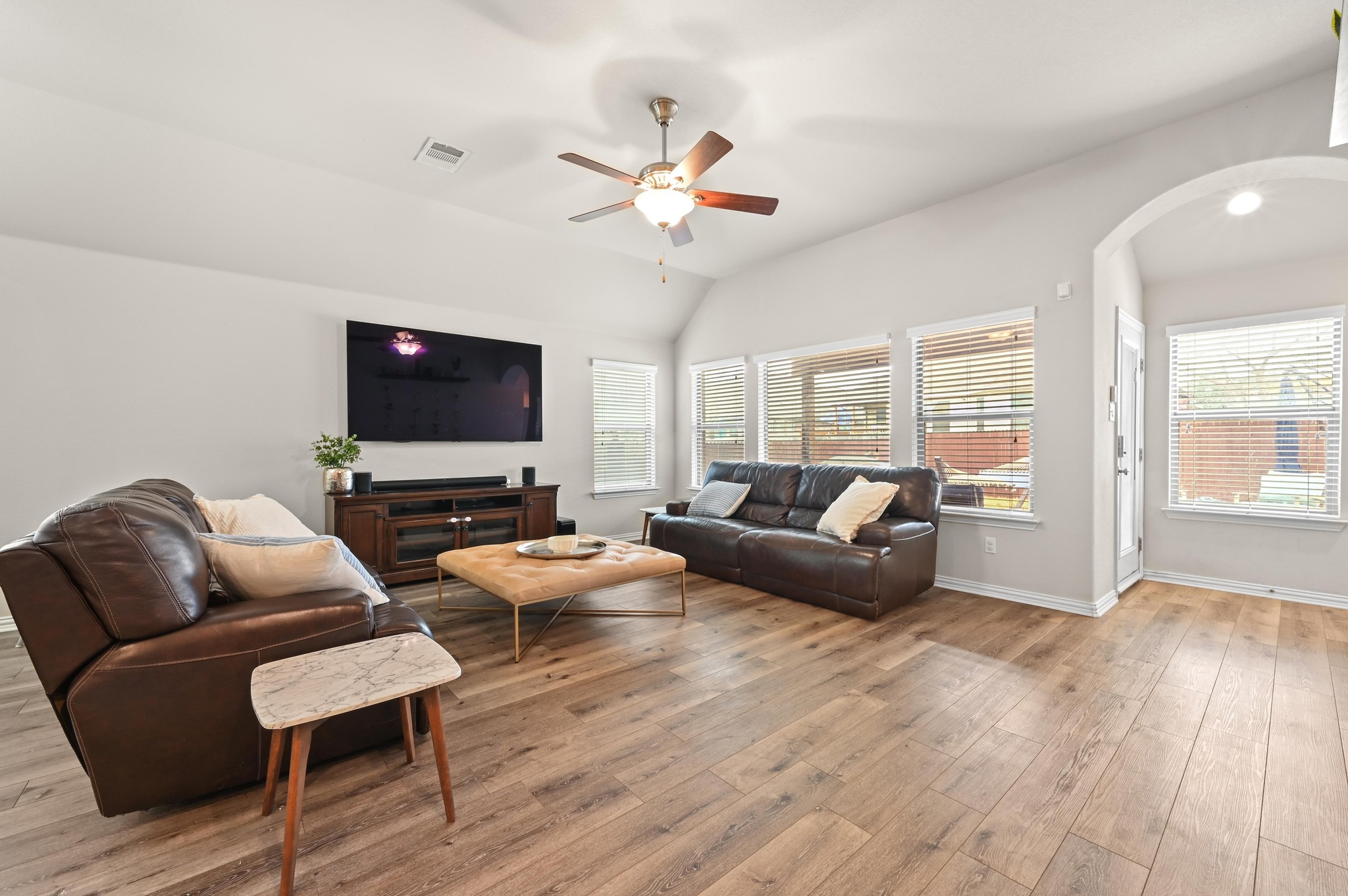 546 Hot Spring Valley Buda, TX 78610 - Photo 12 of 27 Living room featuring a ceiling fan, light wood-type flooring, healthy amount of natural light, vaulted ceiling, and arched walkways