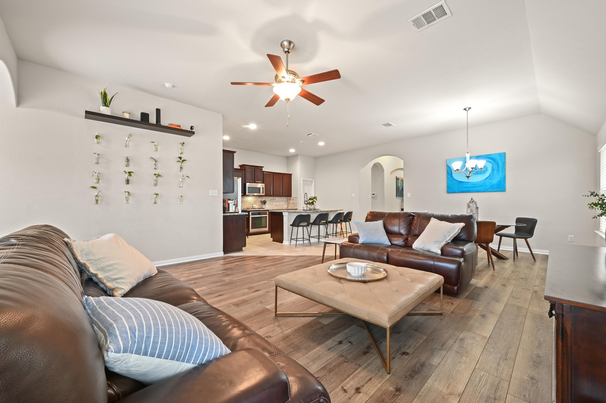 546 Hot Spring Valley Buda, TX 78610 - Photo 14 of 27 Living area with arched walkways, light wood-style floors, a ceiling fan, suspended lighting, and lofted ceiling