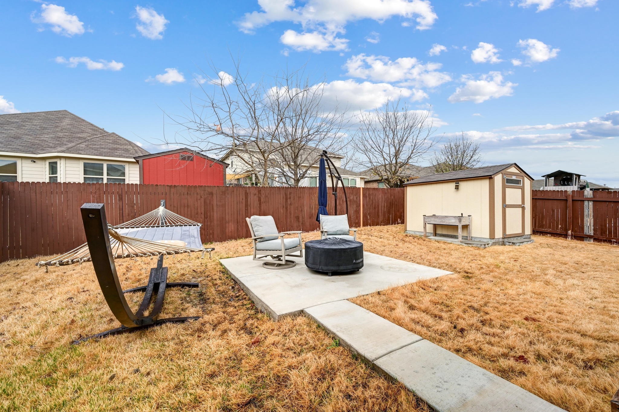 546 Hot Spring Valley Buda, TX 78610 - Photo 25 of 27 Fenced backyard with a patio area, a storage shed, and a fire pit