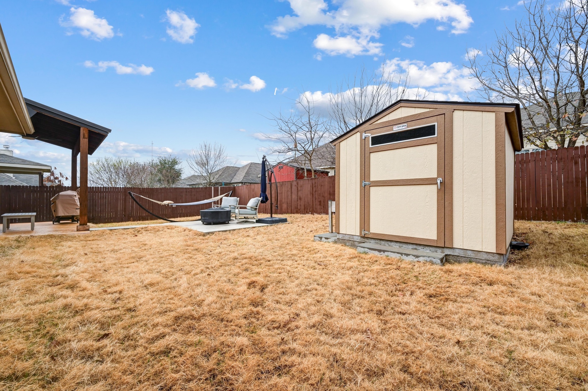 546 Hot Spring Valley Buda, TX 78610 - Photo 27 of 27 Fenced backyard featuring a patio and a storage unit