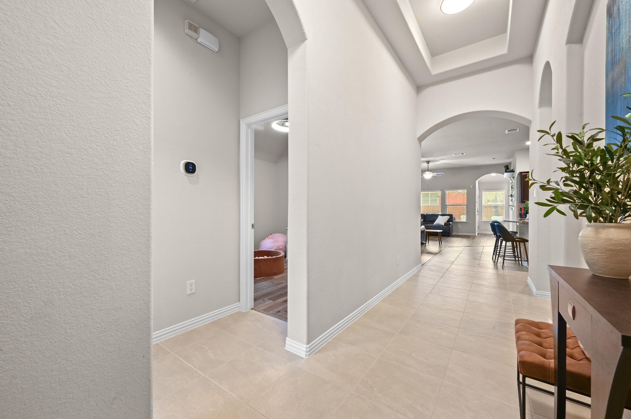546 Hot Spring Valley Buda, TX 78610 - Photo 5 of 27 Hall with arched walkways, a raised ceiling, a textured wall, and light tile patterned floors