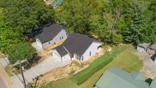 an aerial view of residential houses with outdoor space and trees