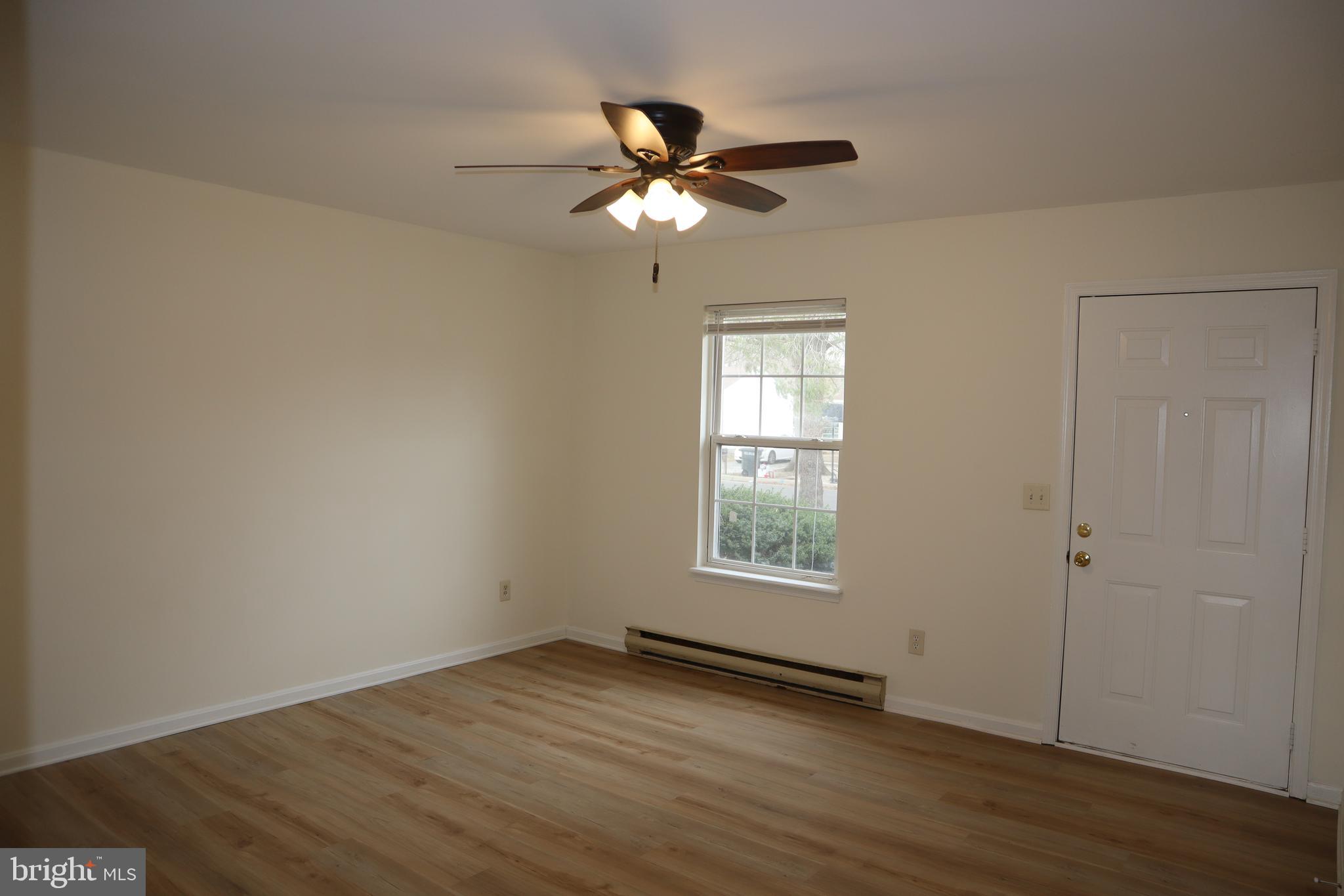 2 West Pine Street Delmar, MD 21875 - Photo 2 of 23 an empty room with wooden floor fan and windows