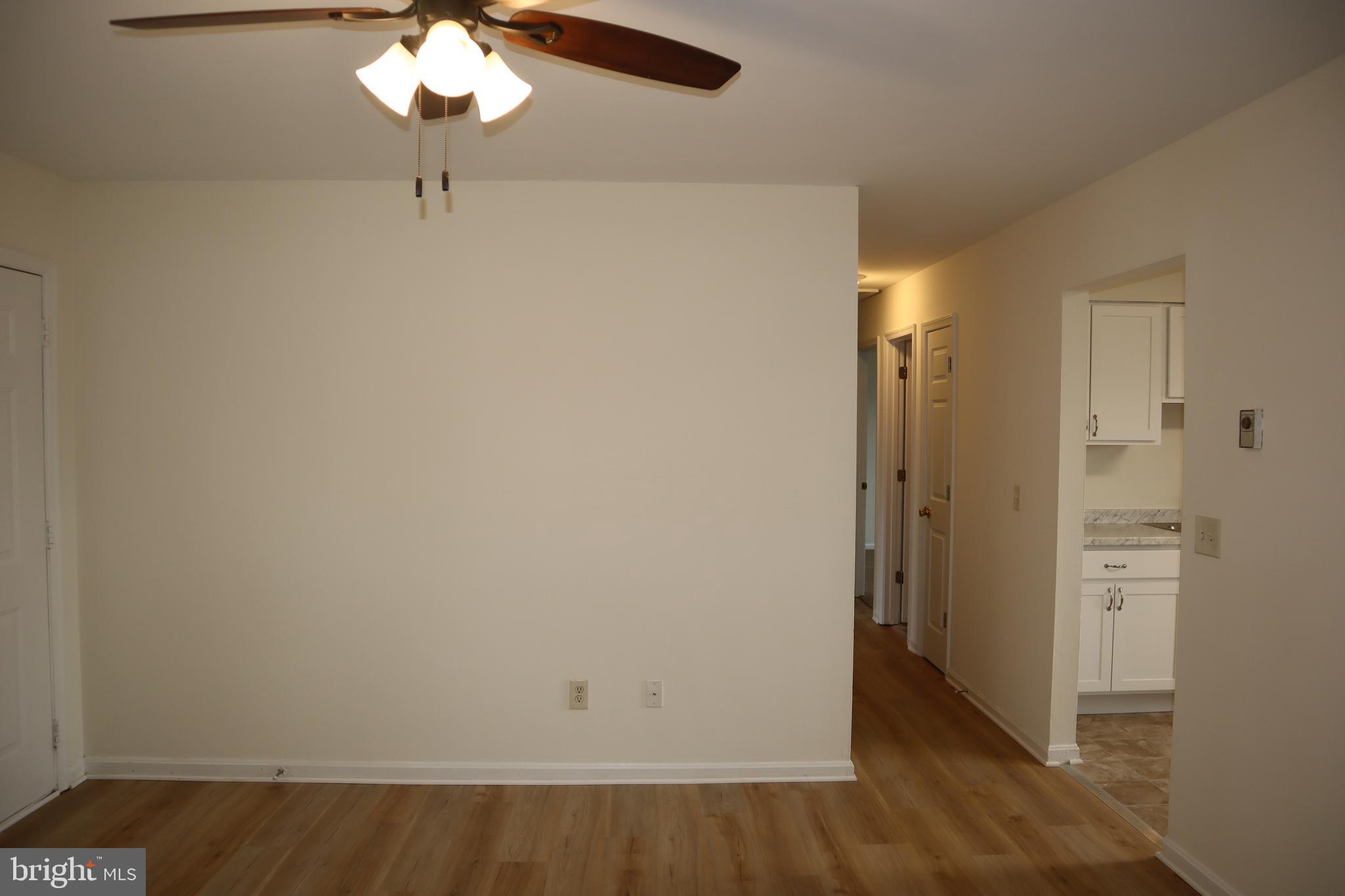 2 West Pine Street Delmar, MD 21875 - Photo 5 of 23 an empty room with wooden floor and chandelier fan