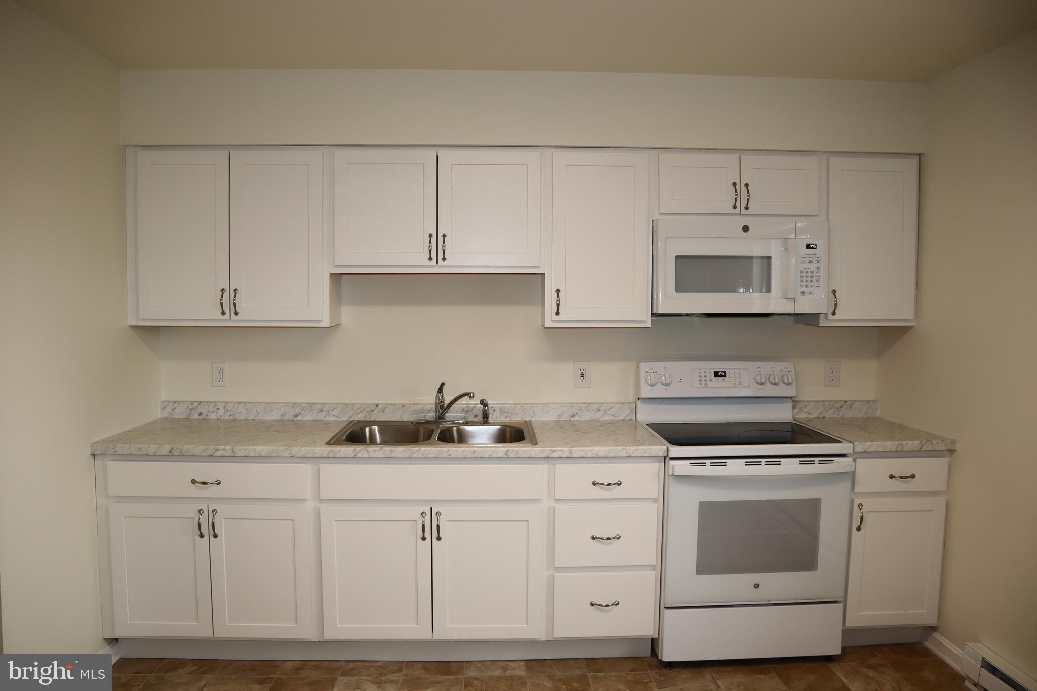 2 West Pine Street Delmar, MD 21875 - Photo 7 of 23 a kitchen with white cabinets and white appliances