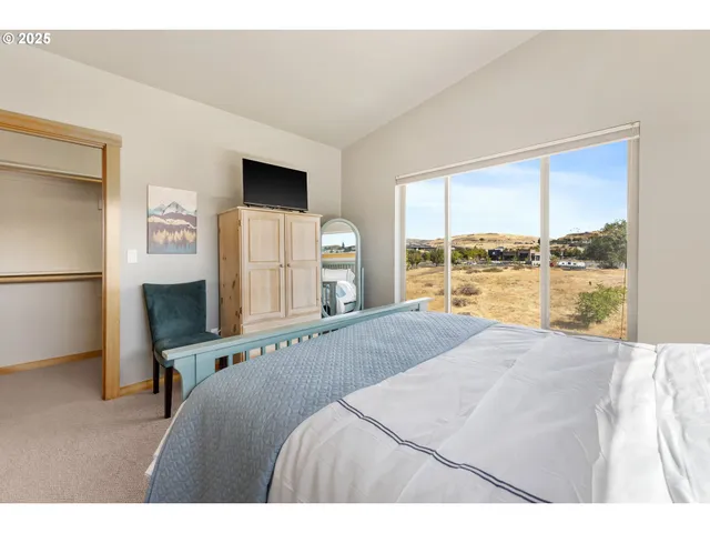 a bedroom with a large window and a bed