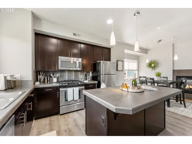 a kitchen with refrigerator and chairs