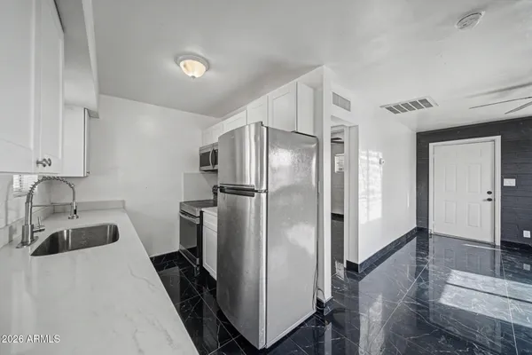 a kitchen with a refrigerator and a sink