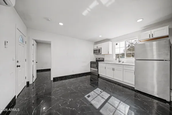 a kitchen with white cabinets and white appliances