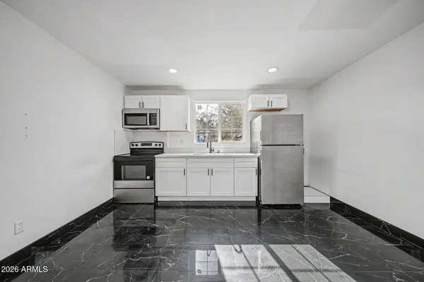 a kitchen with white cabinets and white appliances