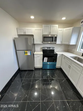 a kitchen with a sink a stove a microwave and cabinets