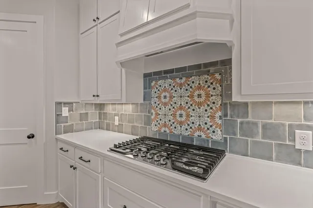 a kitchen with white cabinets and appliances
