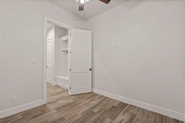 an empty room with wooden floor sink and closet
