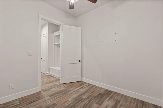 an empty room with wooden floor sink and closet