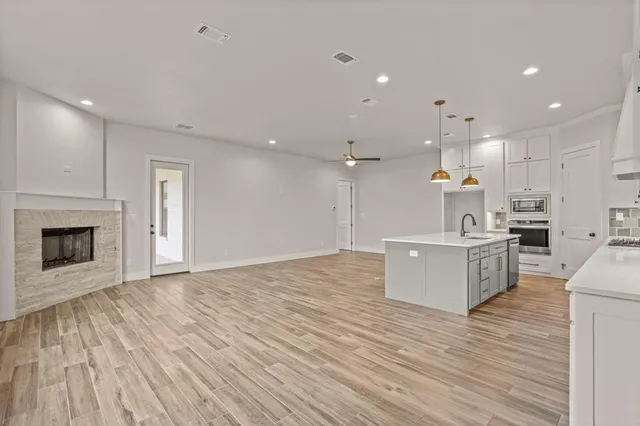a large kitchen with a lot of cabinets and wooden floor