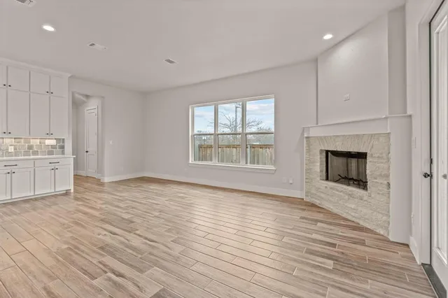 a view of an empty room with a fireplace and a window