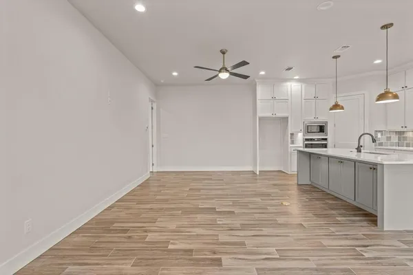 a view of a kitchen with kitchen island a sink stainless steel appliances and cabinets