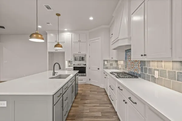 a kitchen with a sink stove top oven and cabinets