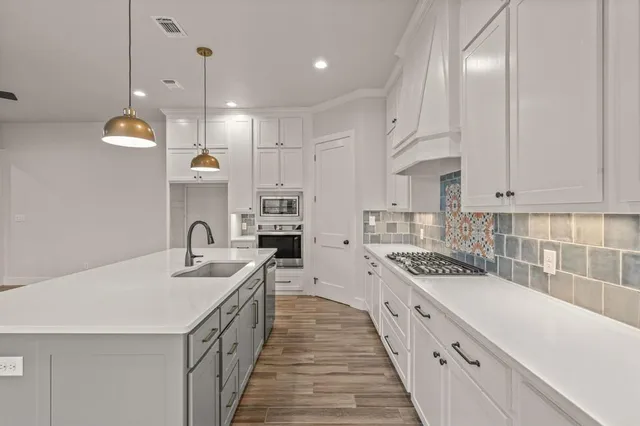 a kitchen with a sink stove top oven and cabinets