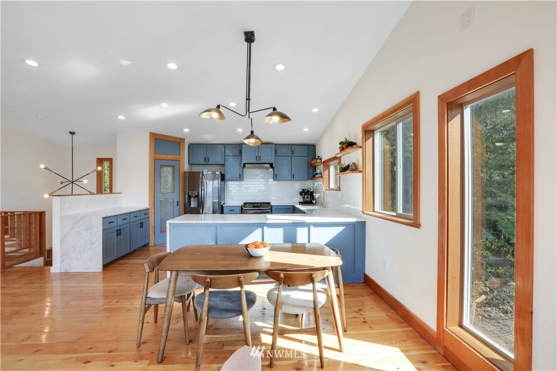 28740 Bacus Road Sedro-Woolley, WA 98284 - Photo 11 of 40 a kitchen with stainless steel appliances granite countertop a stove a refrigerator a sink dishwasher a dining table and chairs with wooden floor