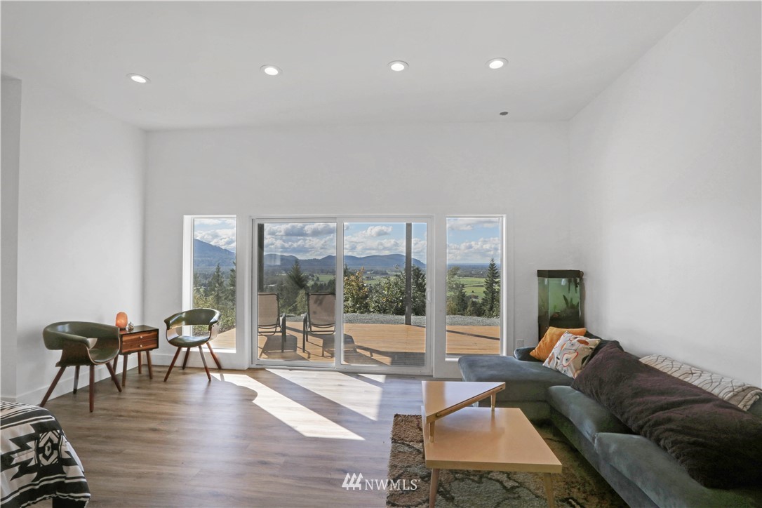28740 Bacus Road Sedro-Woolley, WA 98284 - Photo 25 of 40 a living room with furniture large windows and wooden floor