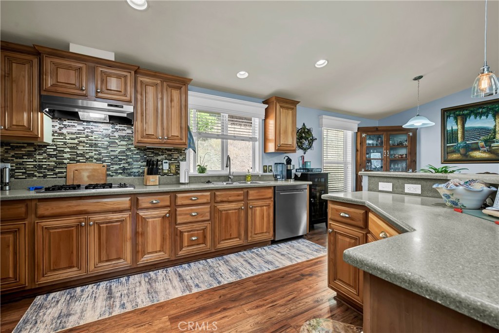 14986 Western Mine Road Middletown, CA 95461 - Photo 11 of 60 a kitchen with granite countertop wooden cabinets a sink a stove a dining table and chairs