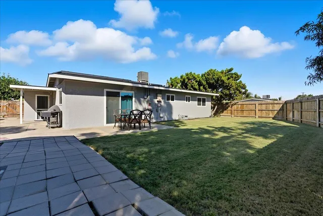 a view of a patio with table and chairs with wooden floor and fence