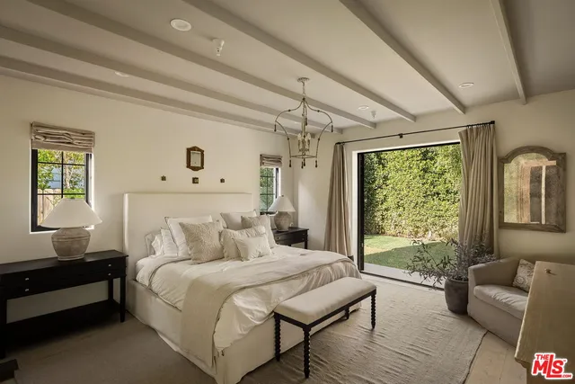 a bedroom with a bed wooden floor and window