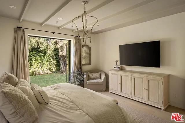 a bedroom with a bed and a flat screen tv